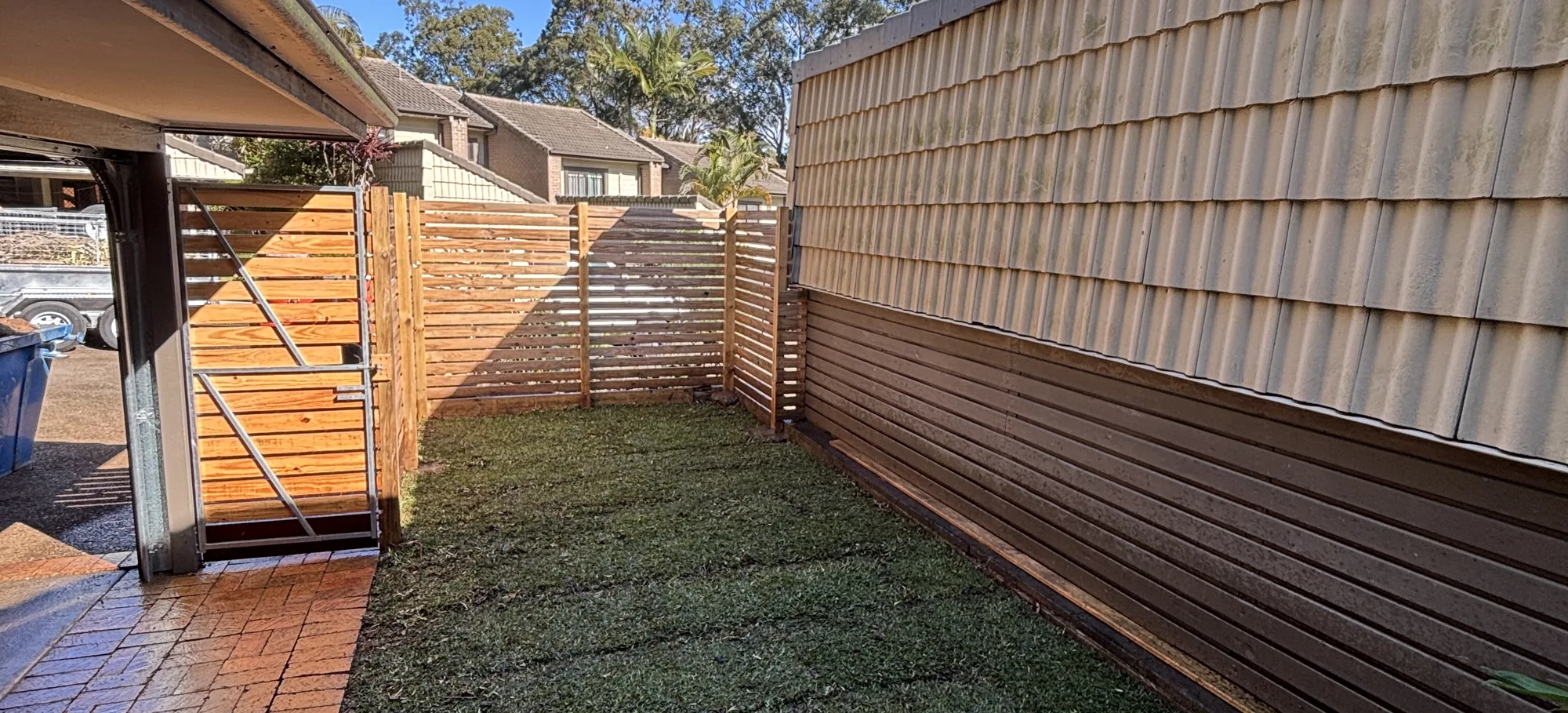 Courtyard finished with a timber slat fence and fresh turf