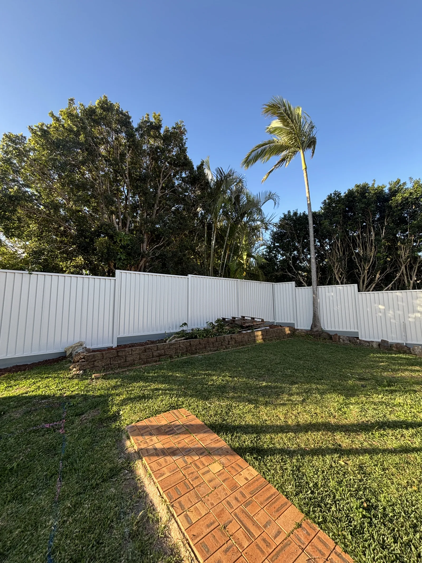 White Colorbond fence around a lawn