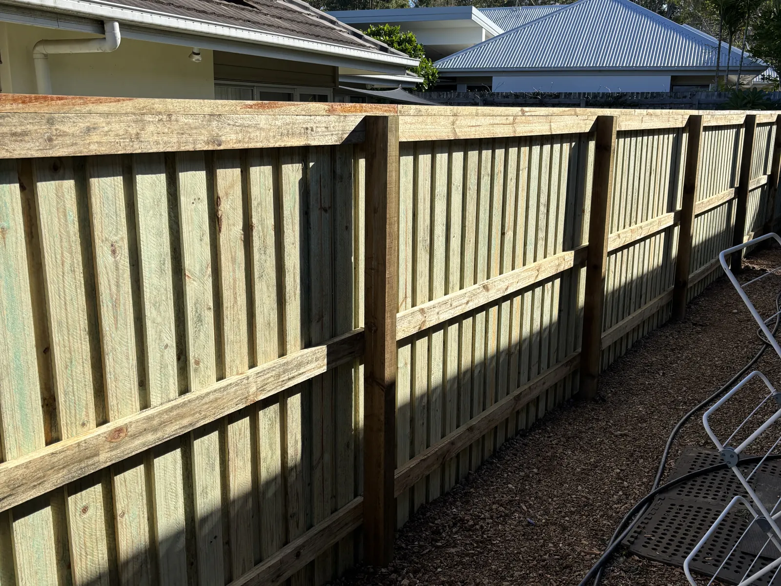Rails and posts on the back of a paling fence