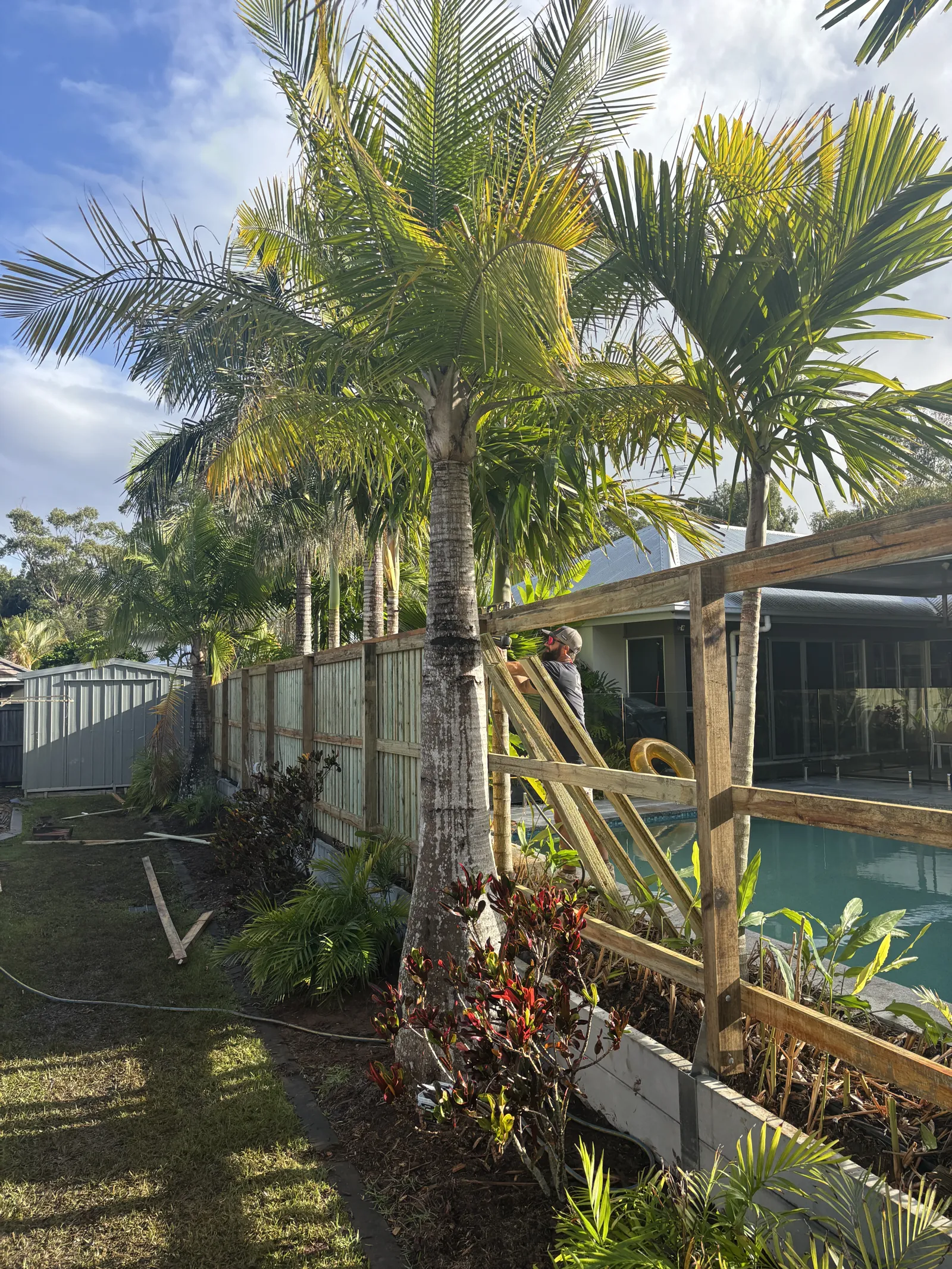 Fence and garden bed being built beside a pool