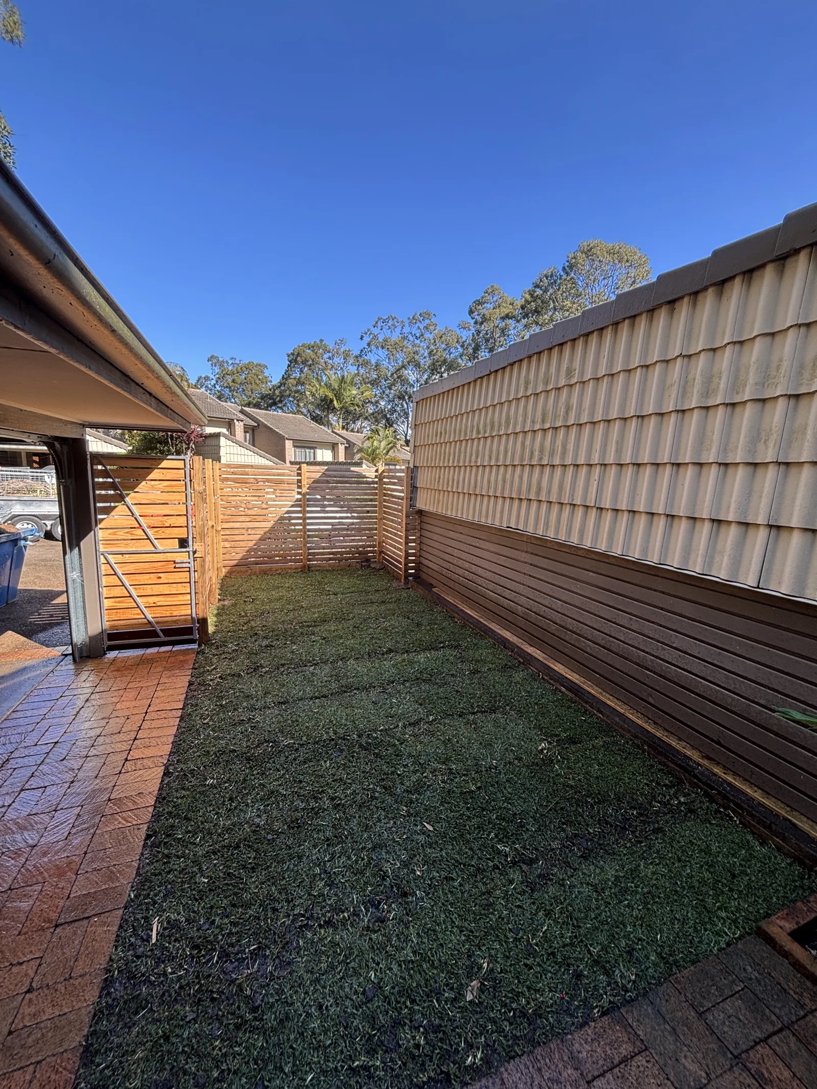 Courtyard with new artificial turf and timber slat screen fence