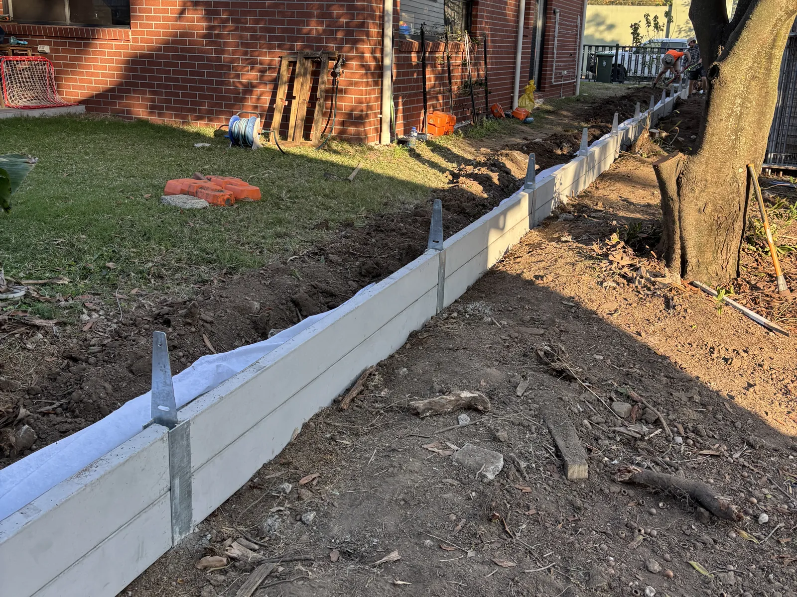 Low concrete sleeper wall along a house