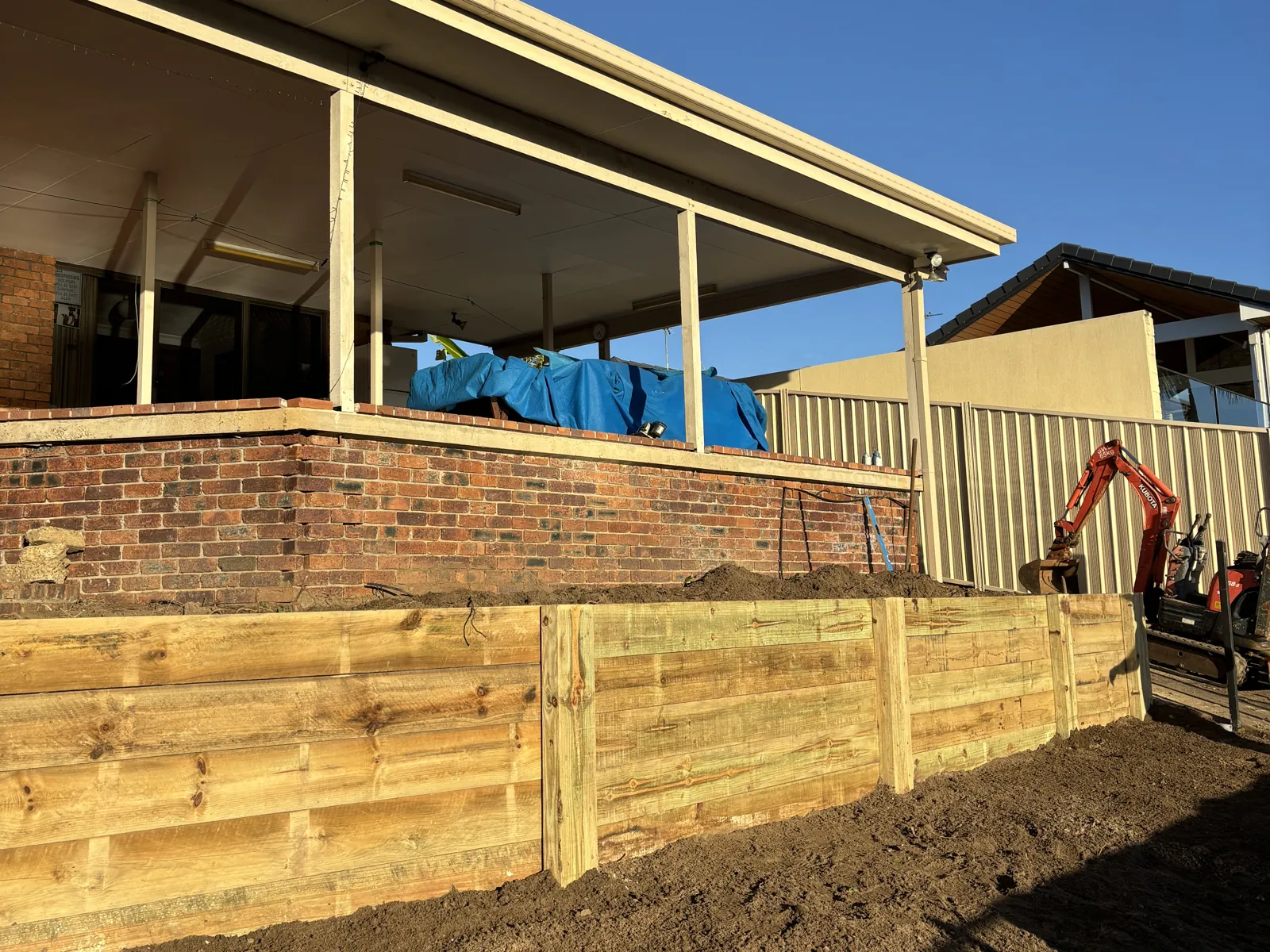 Timber sleeper retaining wall under a deck